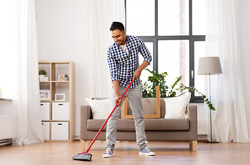 Image showing man with broom cleaning floor at home