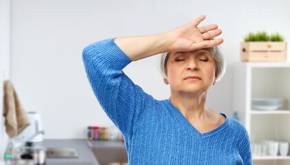 Image showing tired senior woman at kitchen