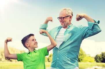 Image showing happy grandfather and grandson showing muscles