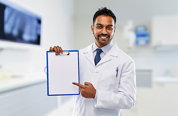 Image showing dentist with paper on clipboard at dental clinic