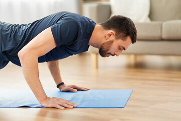 Image showing man doing push ups at home