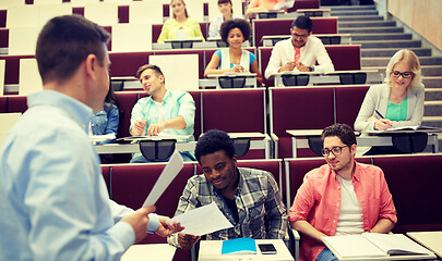 Image showing teacher giving tests to students at lecture