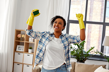 Image showing happy african woman with sponge cleaning at home