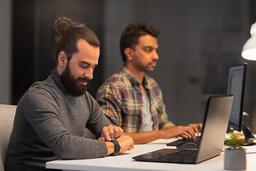 Image showing creative man with smartwatch works at night office