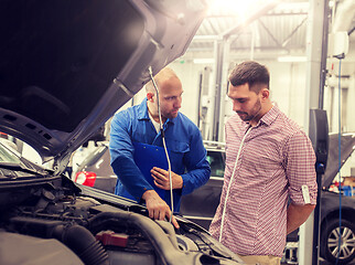 Image showing auto mechanic with clipboard and man at car shop