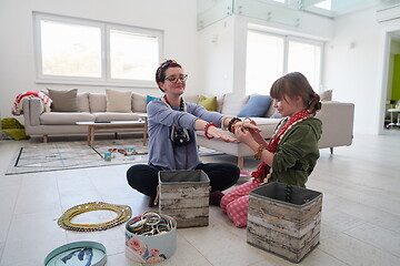 Image showing Mother and little girl daughter playing with jewelry  at home