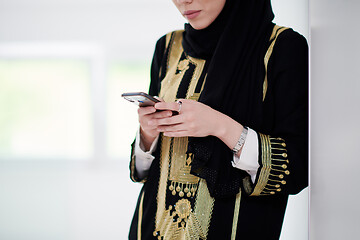 Image showing young modern muslim business woman using smartphone at home