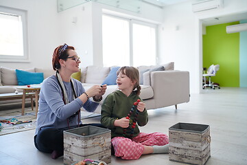 Image showing Mother and little girl daughter playing with jewelry  at home