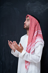 Image showing arabian man making traditional prayer to God, keeps hands in pra