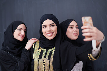 Image showing muslim women taking selfie picture in front of black chalkboard