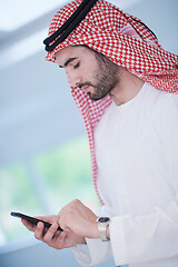 Image showing young arabian businessman using smartphone at home