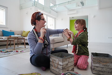 Image showing Mother and little girl daughter playing with jewelry  at home