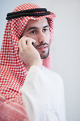 Image showing young arabian businessman using smartphone at home