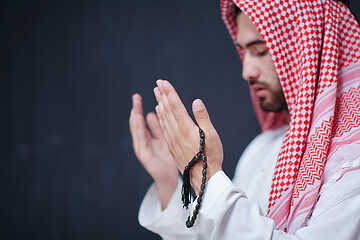 Image showing arabian man making traditional prayer to God, keeps hands in pra