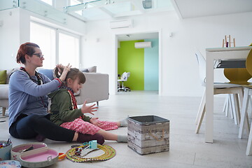 Image showing Mother and little girl daughter playing with jewelry  at home