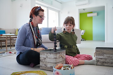 Image showing Mother and little girl daughter playing with jewelry  at home