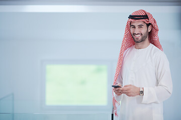 Image showing young arabian businessman using smartphone at home