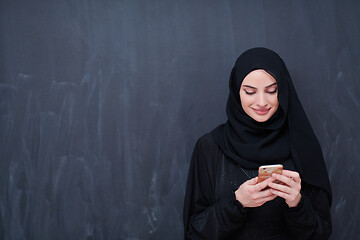 Image showing young modern muslim business woman using smartphone