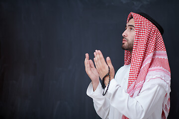 Image showing arabian man making traditional prayer to God, keeps hands in pra