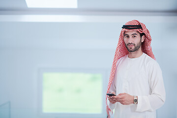 Image showing young arabian businessman using smartphone at home