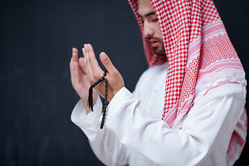 Image showing arabian man making traditional prayer to God, keeps hands in pra