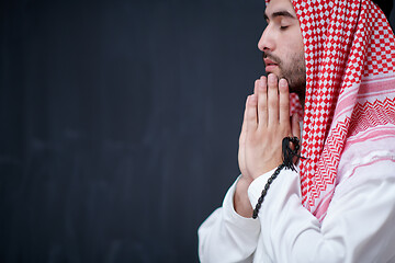 Image showing arabian man making traditional prayer to God, keeps hands in pra