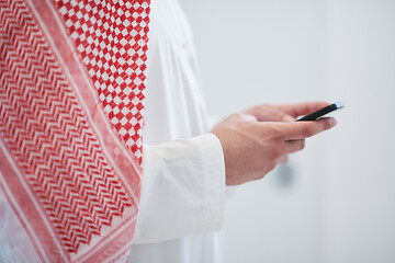 Image showing young arabian businessman using smartphone at home