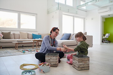 Image showing Mother and little girl daughter playing with jewelry  at home