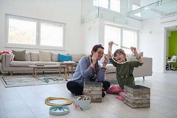 Image showing Mother and little girl daughter playing with jewelry  at home