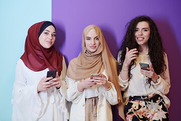 Image showing muslim women in fashionable dress isolated on colorful backgroun