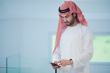 Image showing young arabian businessman using smartphone at home