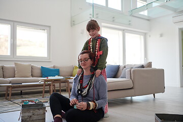 Image showing Mother and little girl daughter playing with jewelry  at home