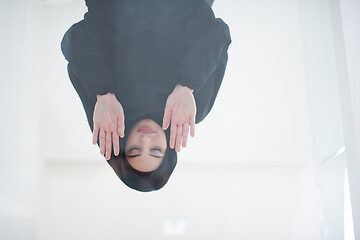 Image showing young arabian muslim woman praying on the glass floor at home