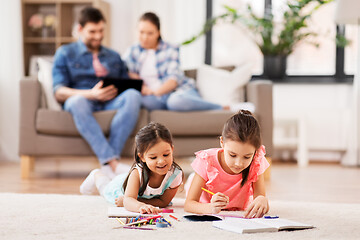 Image showing happy sisters drawing in sketchbooks at home