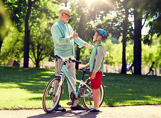 Image showing grandfather and boy with bicycle at summer park