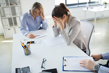Image showing stressed business team with papers at office
