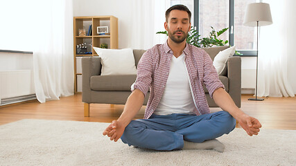 Image showing man with tablet computer meditating at home