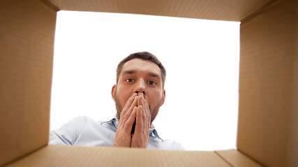 Image showing shocked man looking into open parcel box