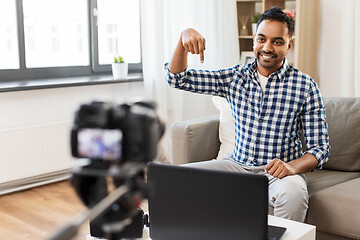 Image showing male blogger with camera videoblogging at home