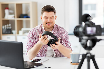 Image showing male blogger with headphones videoblogging at home