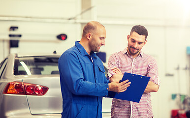 Image showing auto mechanic with clipboard and man at car shop