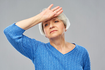 Image showing tired senior woman suffering from headache