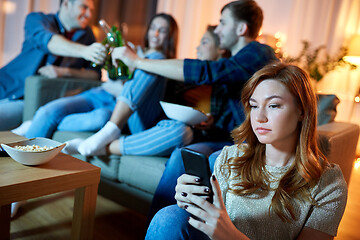 Image showing sad young woman with smartphone at home party