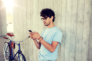 Image showing man with smartphone and fixed gear bike on street