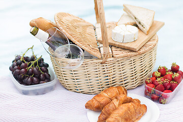 Image showing picnic basket, food and wine glasses on blanket