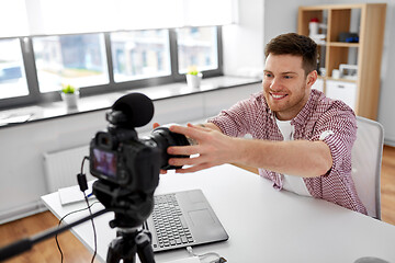 Image showing male video blogger adjusting camera at home office