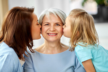 Image showing mother and daughter kissing happy grandmother