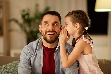 Image showing happy daughter whispering secret to father at home