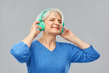 Image showing senior woman in headphones listening to music