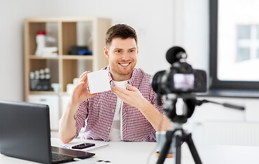 Image showing male blogger with camera videoblogging at home